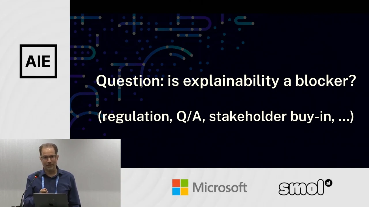Slide asks “is explainability a blocker?” and lists “regulation, Q/A, stakeholder buy-in, ...” with the presenter inset at lower left.