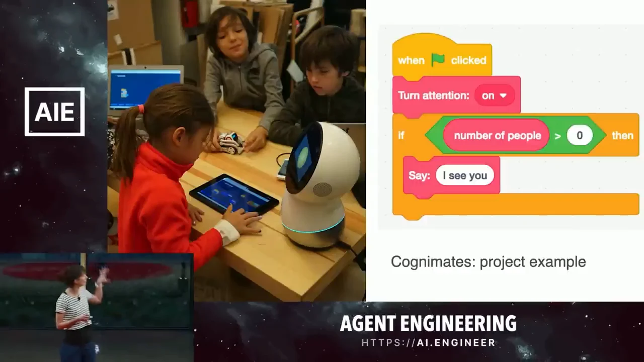 Children gathered around a robot beside blocks that turn attention on and say “I see you” when the number of people exceeds zero.