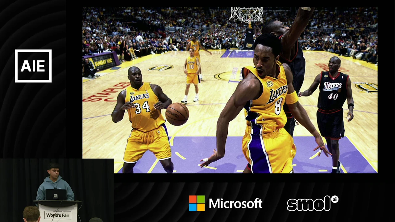 Basketball photograph showing Lakers players in yellow jerseys numbered 34 and 8, with the speaker inset at lower left.