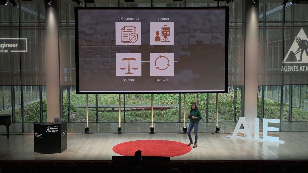Projected slide displays four icons in a two-by-two grid labeled AI Governance, Control, Balance, and Lifecycle, with the speaker standing below.