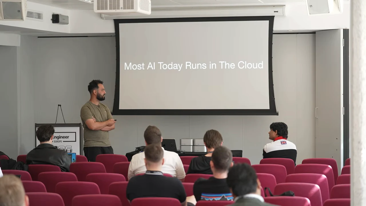 Presenter beside a slide reading “Most AI Today Runs in The Cloud.”