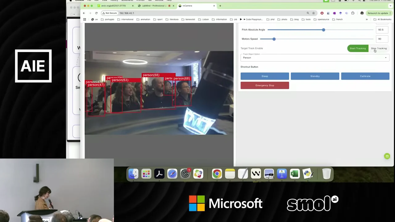 Camera control interface with red person-detection boxes around audience members and tracking and movement controls alongside the video.