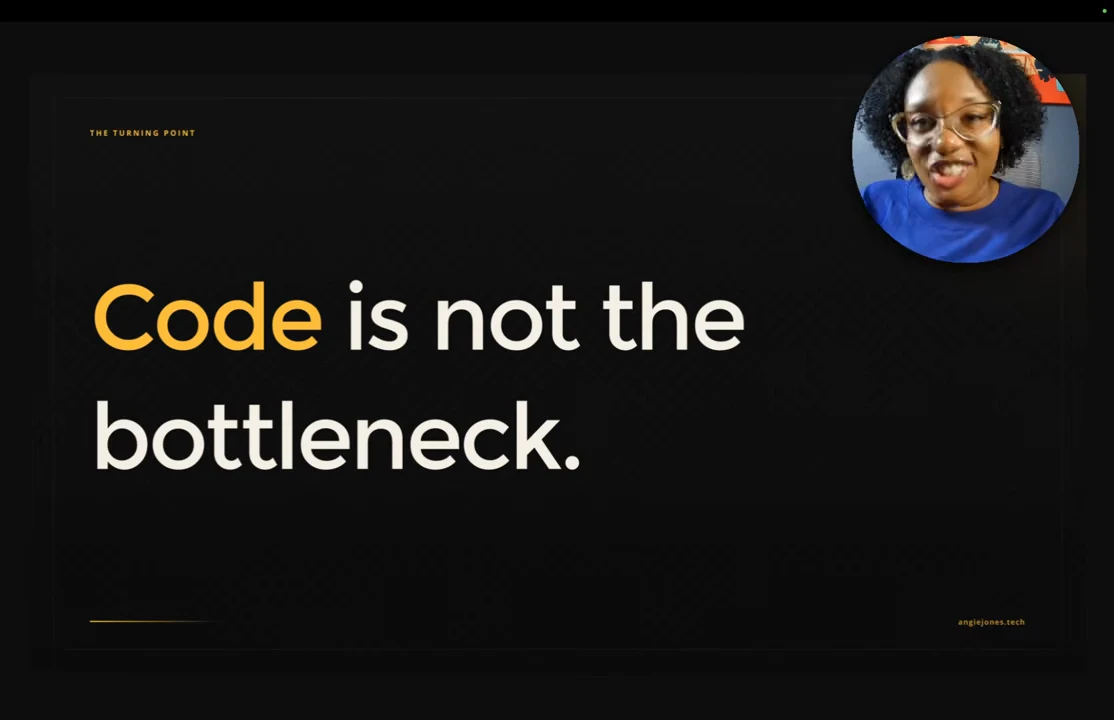 Black slide reading “Code is not the bottleneck,” with “Code” in gold and the speaker inset at upper right.