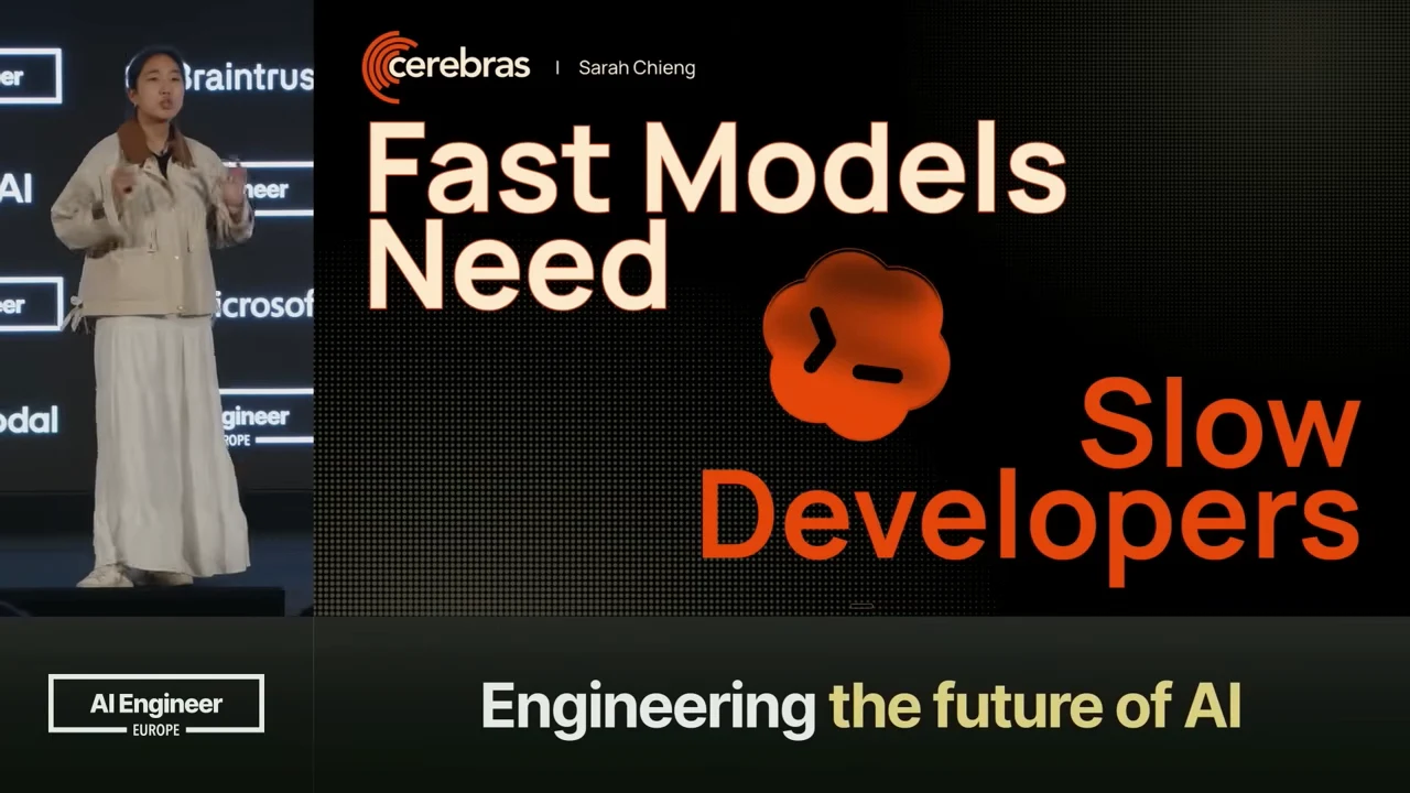 Sarah Chieng stands beside the complete title slide, with cream and orange lettering on black.