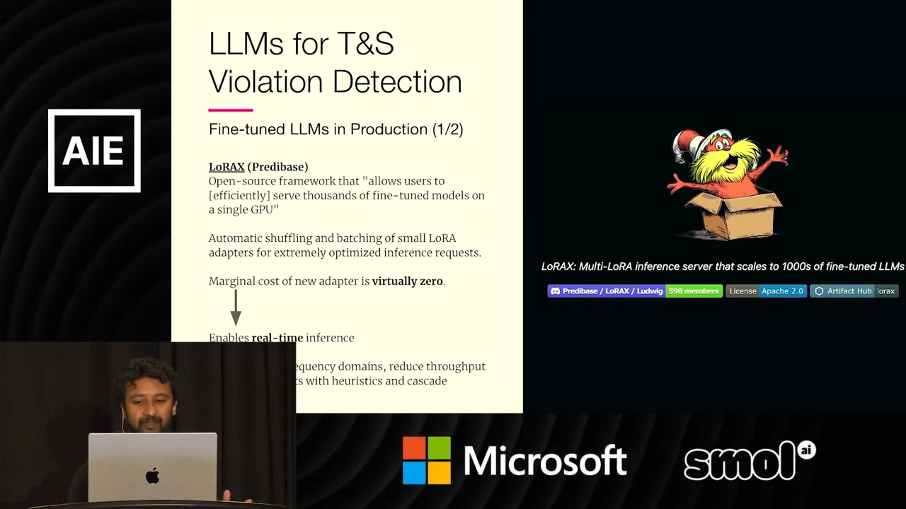 Production slide describing LoRAX, batching small LoRA adapters, and virtually zero marginal cost per new adapter, beside a cartoon mascot and project banner. The speaker inset obscures some lower text.