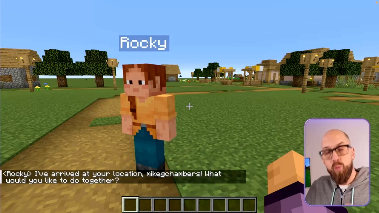 Minecraft character Rocky stands near the player; chat says it has arrived at the player's location and asks what they would like to do together.
