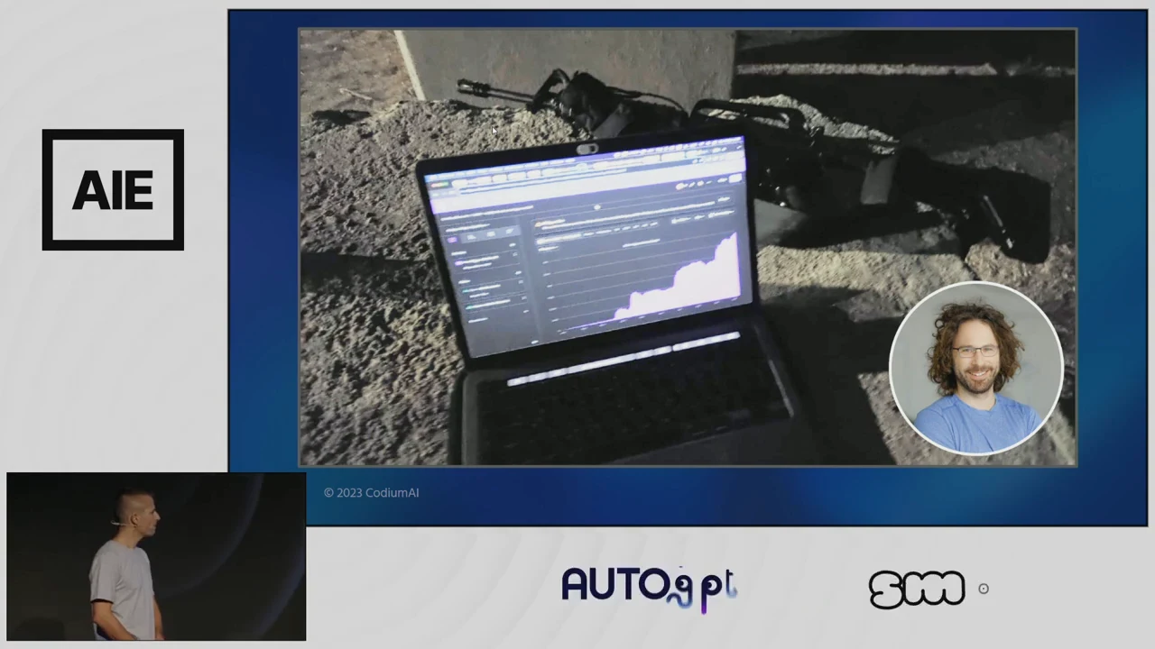 Slide photograph of an open laptop on rough ground, a rifle behind it, and a circular portrait inset.
